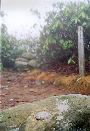 [Image: Benchmark with lookout cairn in background